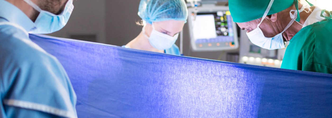 Doctor examining pregnant woman during delivery in operating room